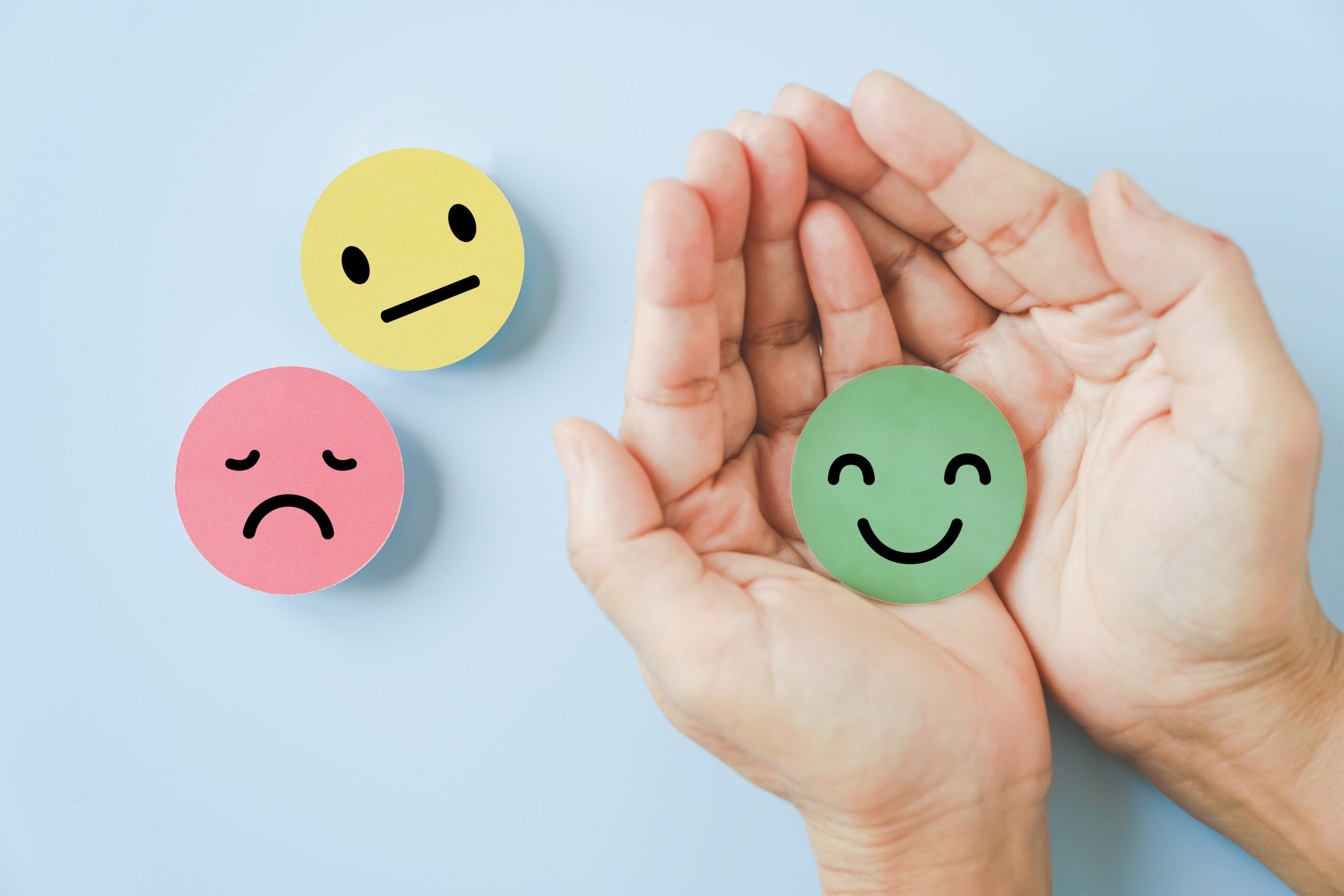 smiling face in hand on blue background satisfaction survey ,good feedback rating and positive customer review, comment, experience, mental health assessment concept