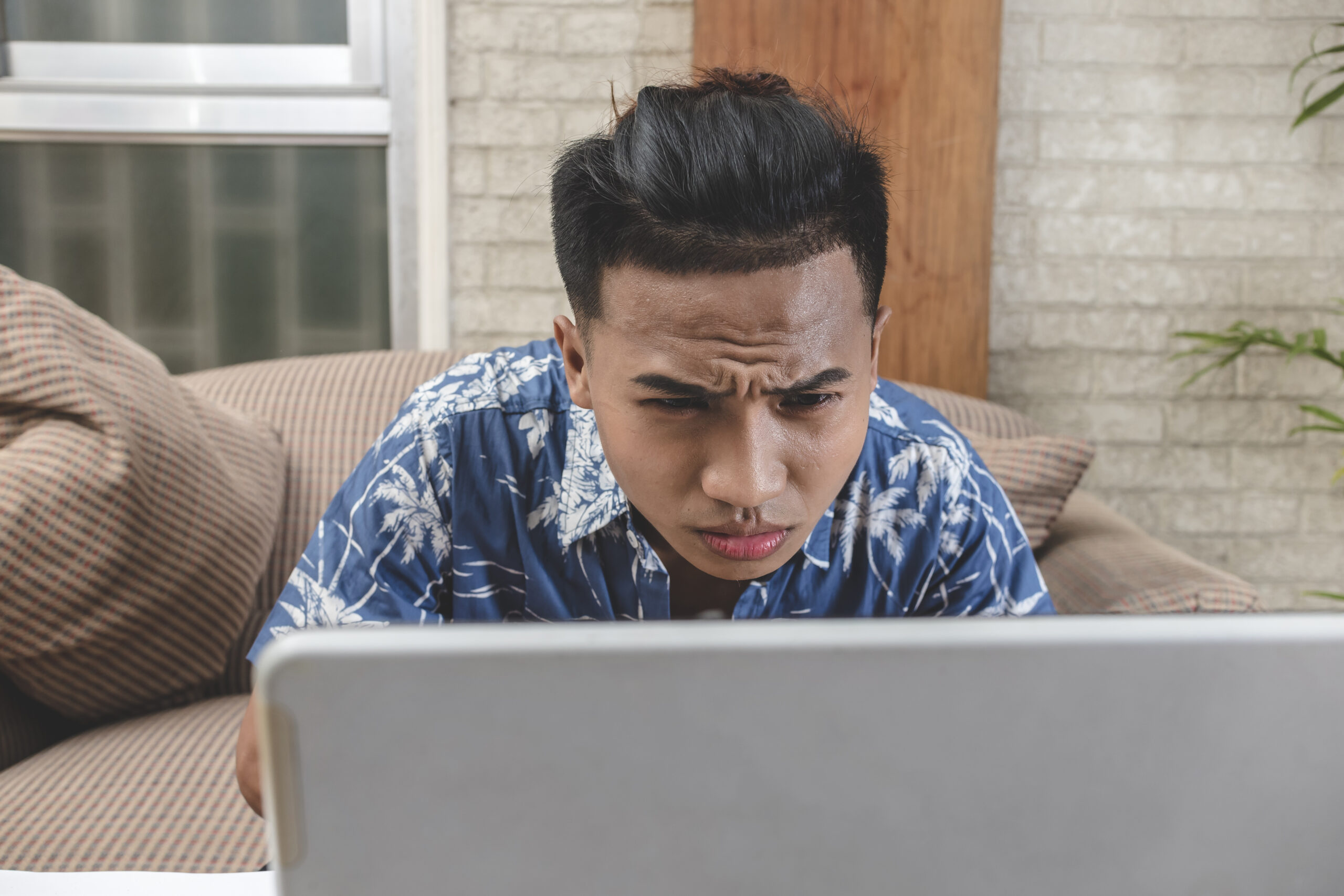 A borderline OCD guy examines the details of his document, squinting at the monitor. A very thorough and perfectionist person.