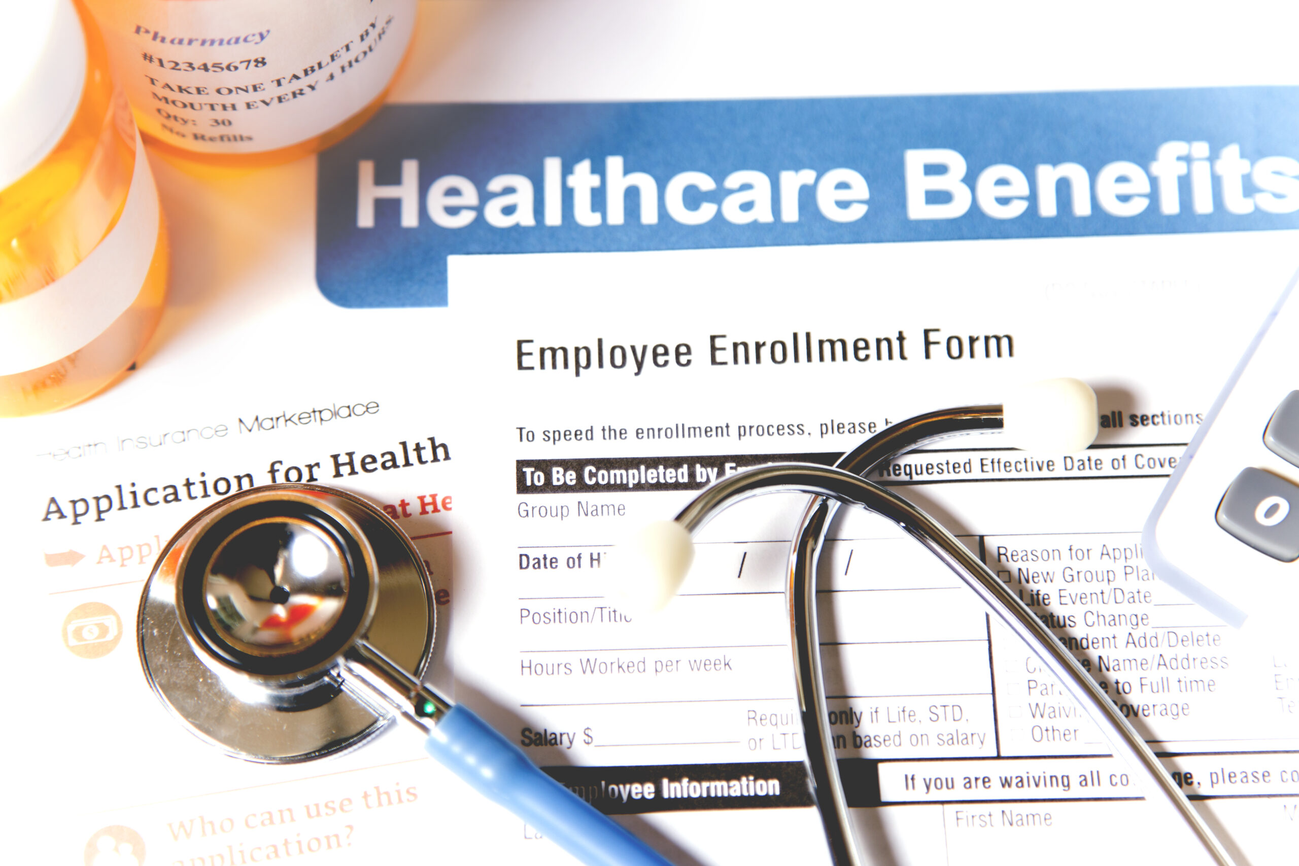 Healthcare benefit forms including: enrollment forms and applications, stethoscope, calculator. Affordable healthcare remains an important topic around the world!