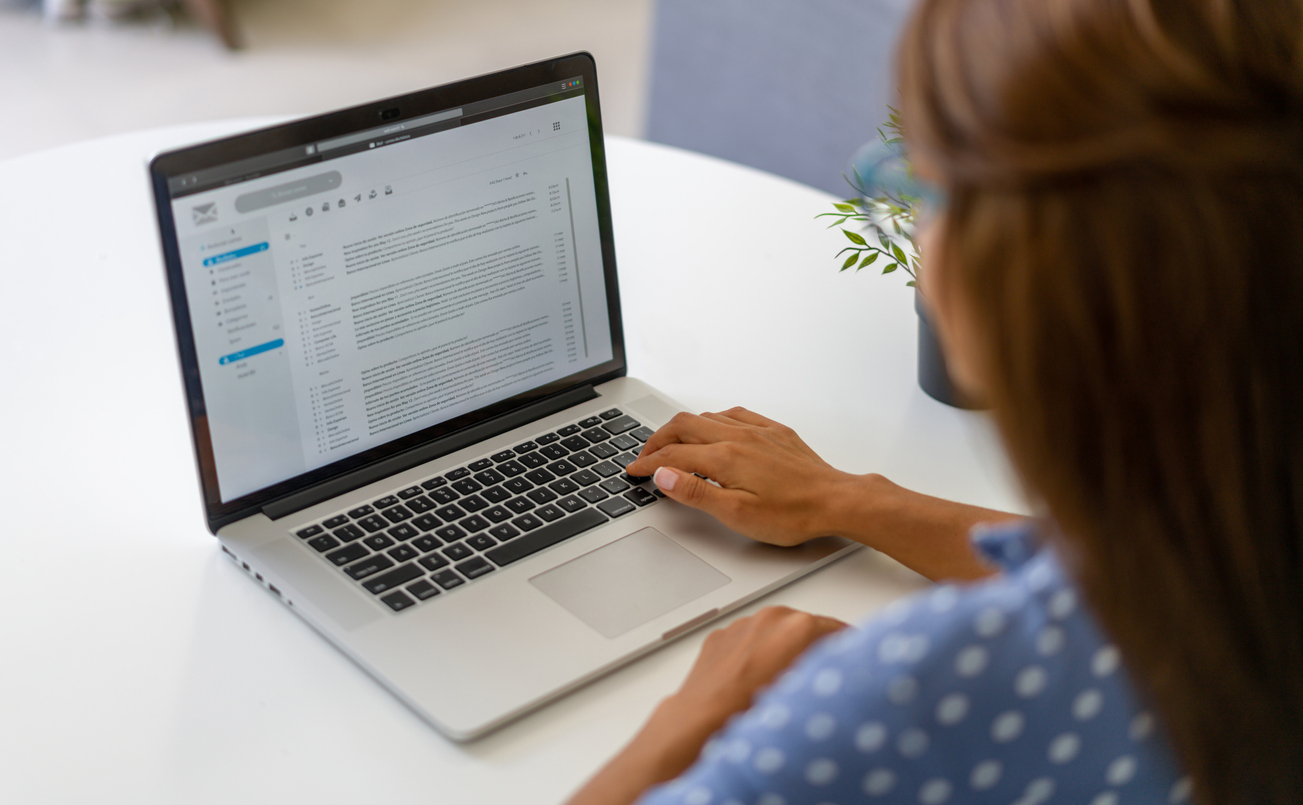 Woman working at home and reading e-mails on her laptop computer. Prep good emails in your comms.